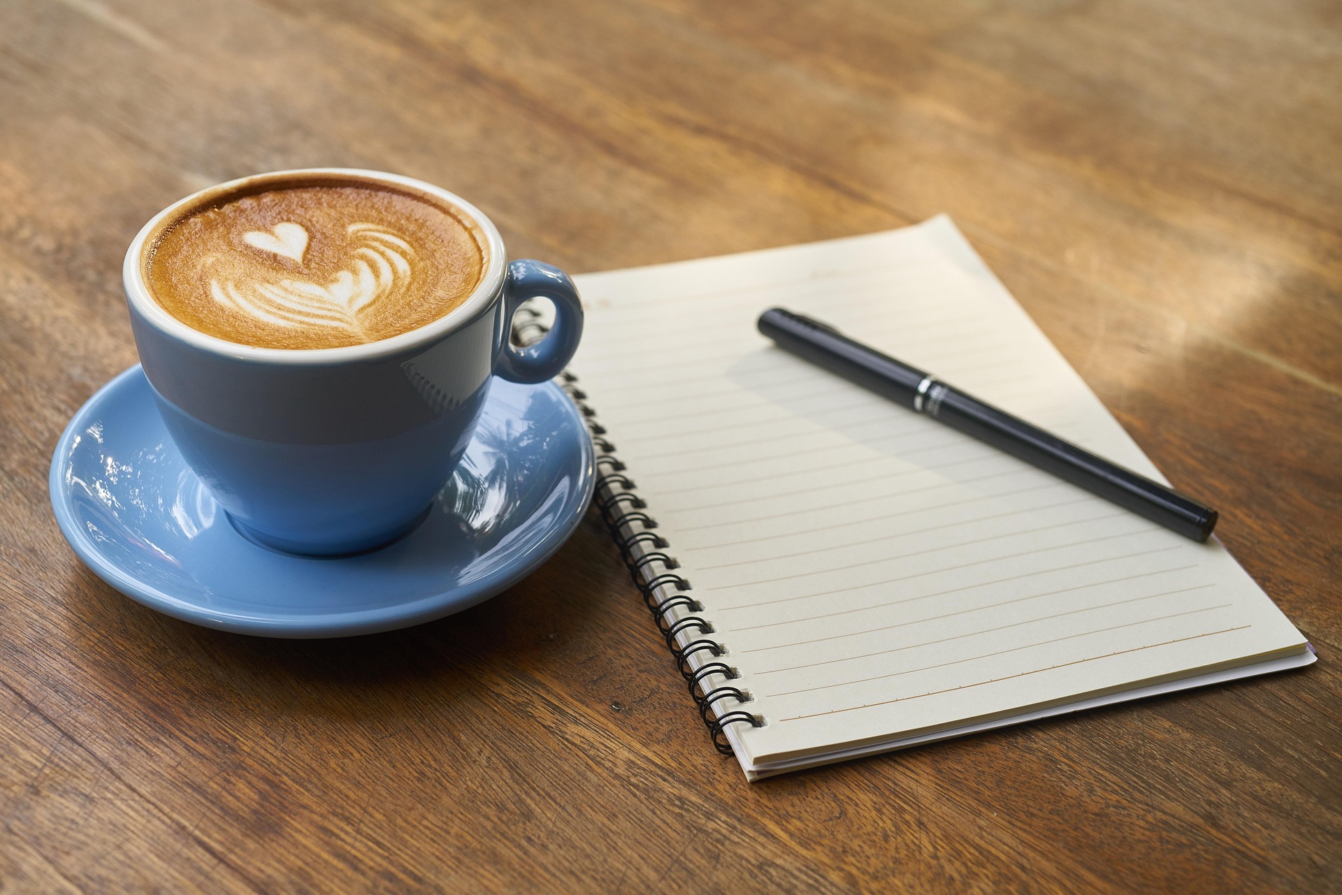coffee cup and notepad with pen
